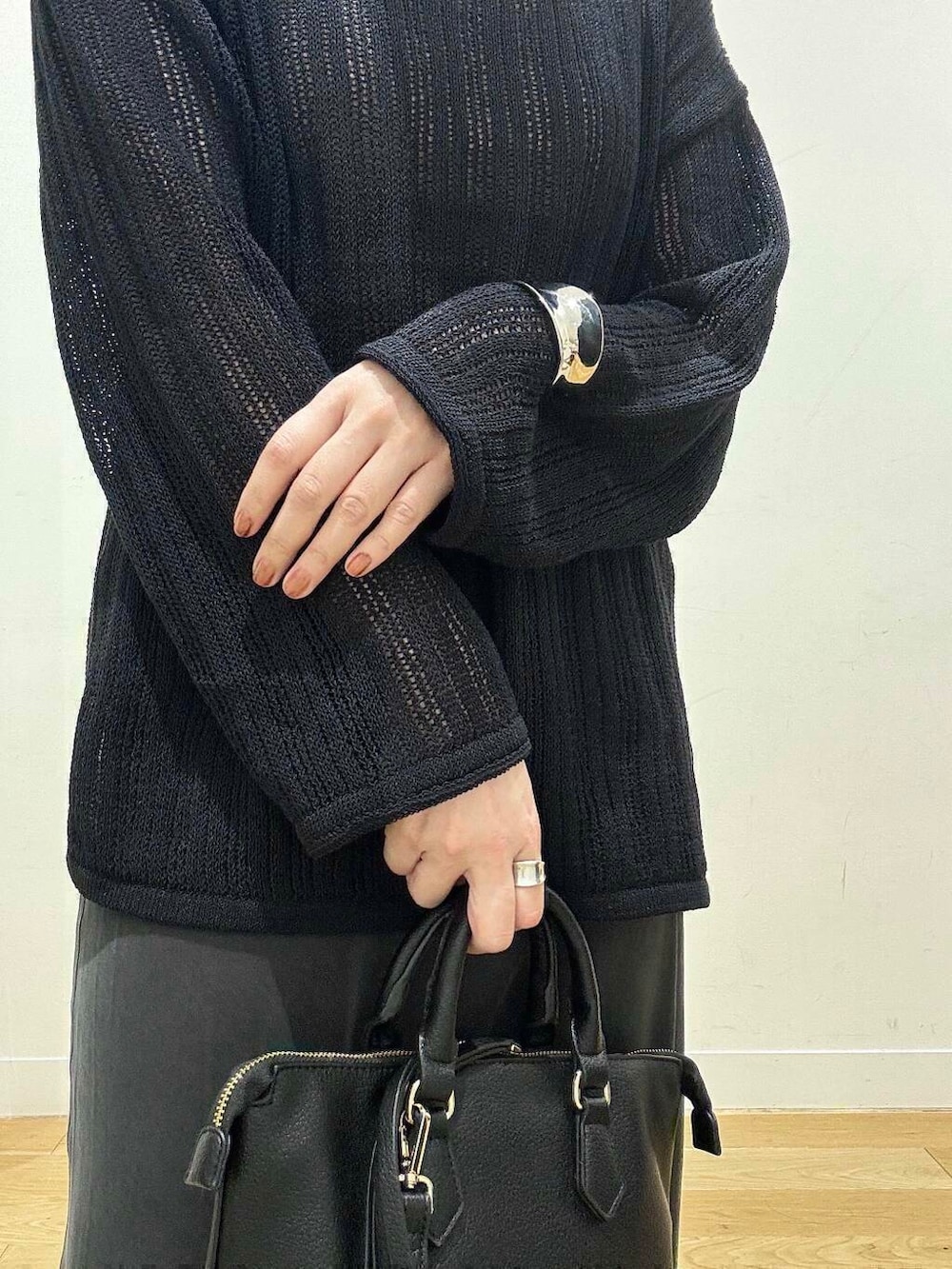 ブラウン系のタンクトップ、グレー系のスカート、ブラック系のボストンバッグを着用したレディースの秋コーディネートの7枚目の写真