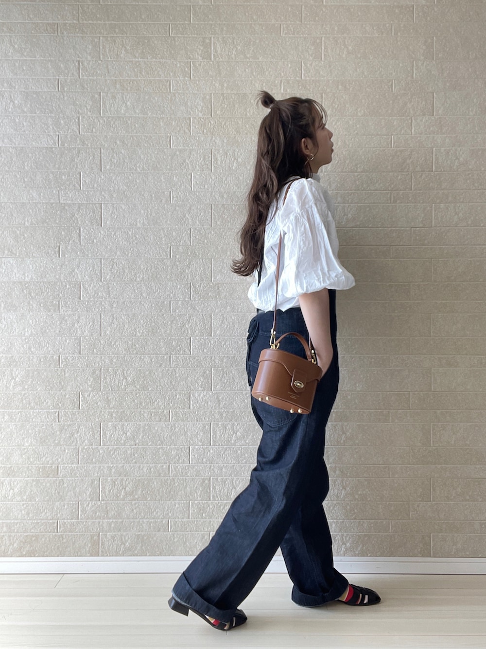 ブルー系のサロペット/オーバーオール、ブラック系のパンプス、イエロー系のハンドバッグを着用したレディースの春コーディネートの2枚目の写真