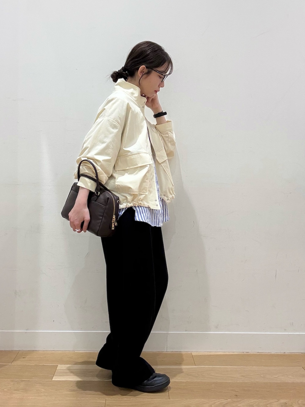 ホワイト系のブルゾン、ブラウン系のボストンバッグ、ブラック系のその他パンツを着用したレディースの春コーディネートの6枚目の写真