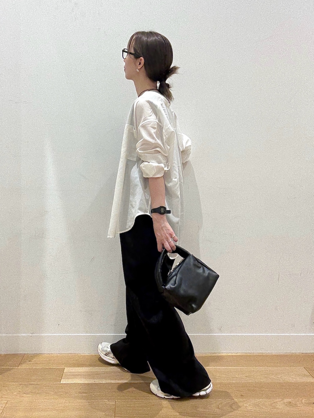 ブラック系のハンドバッグ、ブラック系のワンピース、グレー系のTシャツ/カットソーを着用したレディースの秋コーディネートの4枚目の写真