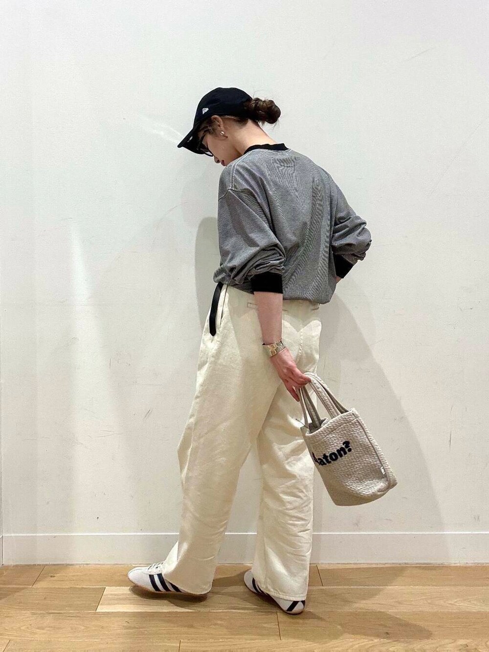 グレー系のカーディガン/ボレロ、ホワイト系のデニムパンツ、グレー系のトートバッグを着用したレディースの冬コーディネートの5枚目の写真