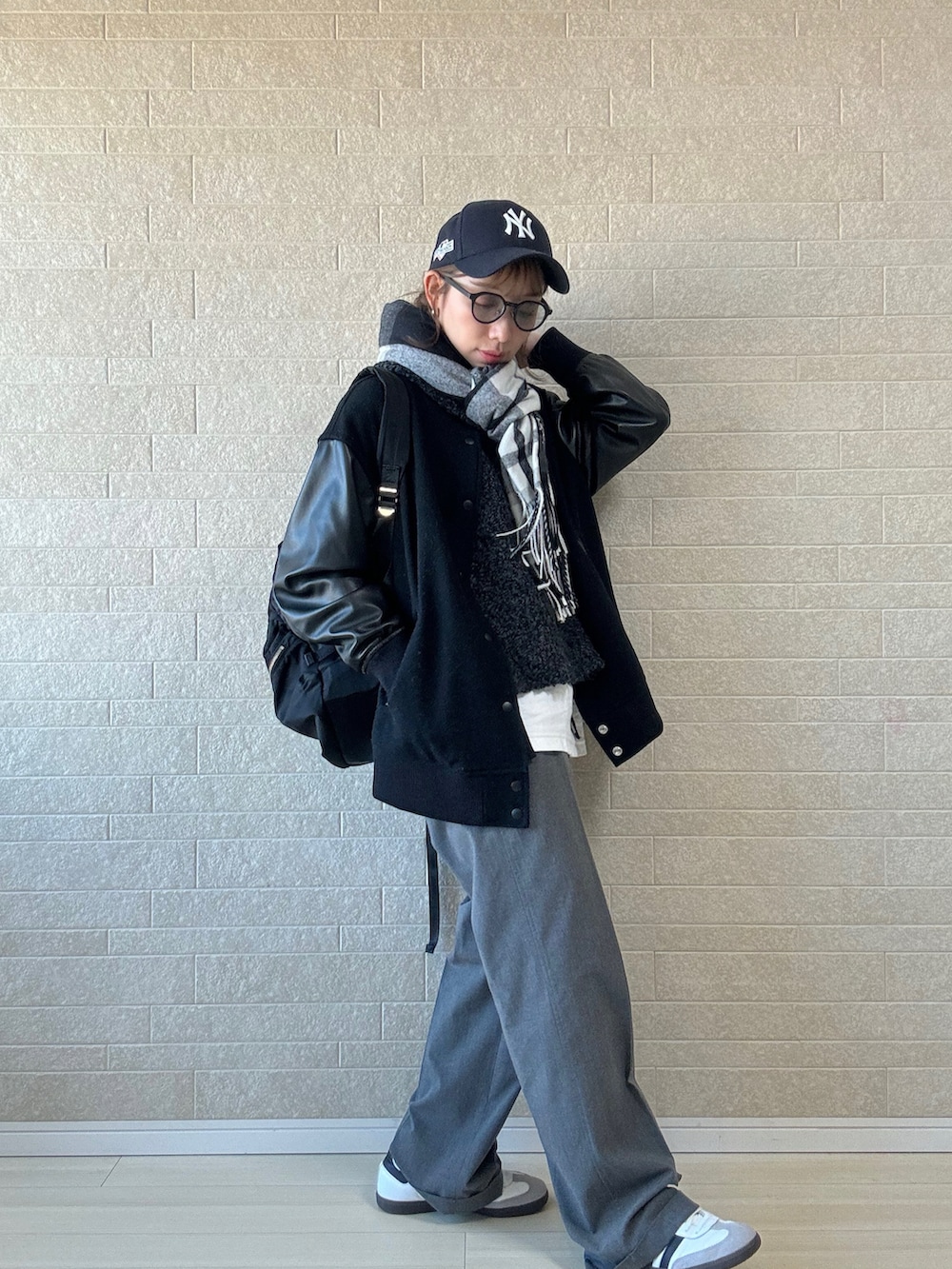 グレー系のベスト、ホワイト系のTシャツ/カットソー、ホワイト系のスニーカーを着用したレディースの冬コーディネートの2枚目の写真