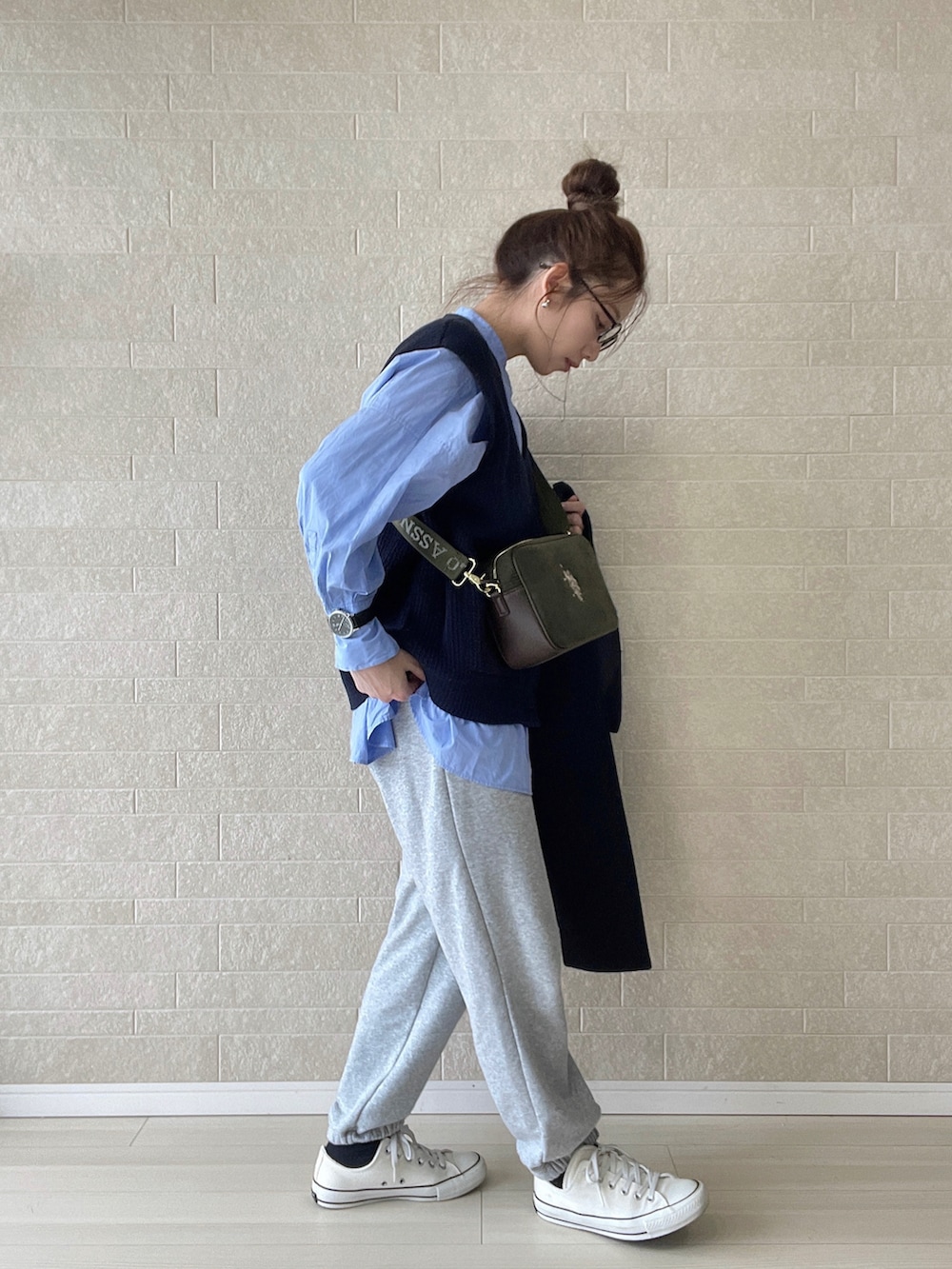 グリーン系のショルダーバッグ、グレー系のスウェットパンツ、ホワイト系のスニーカーを着用したレディースの冬コーディネートの4枚目の写真