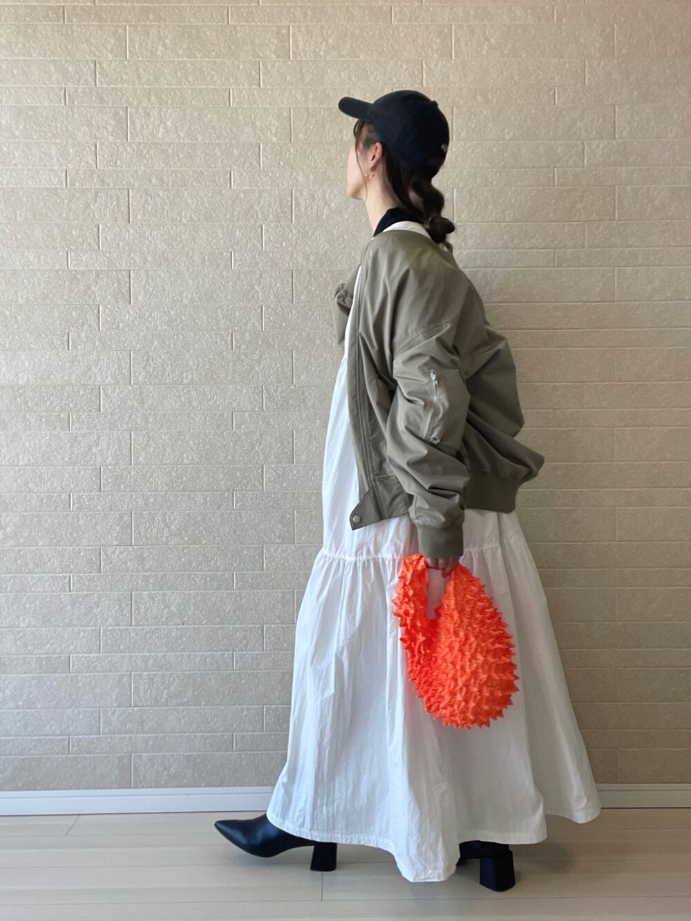 ブラック系のブーツ、ブラック系のニット/セーター、ホワイト系のワンピースを着用したレディースの秋コーディネートの3枚目の写真