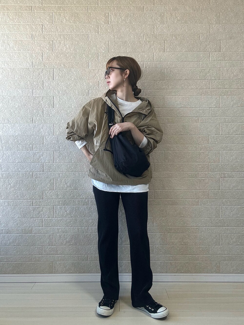 ベージュ系のナイロンジャケット、ホワイト系のTシャツ/カットソー、ブラック系のスニーカーを着用したレディースの春コーディネートの2枚目の写真