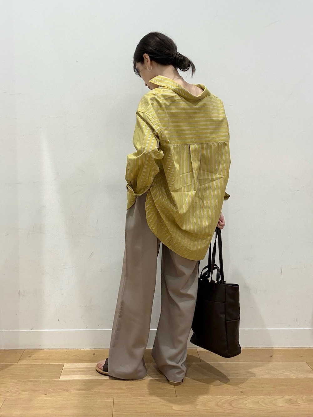 イエロー系のシャツ/ブラウス、ベージュ系のその他パンツ、ブラウン系のサンダルを着用したレディースの夏コーディネートの2枚目の写真
