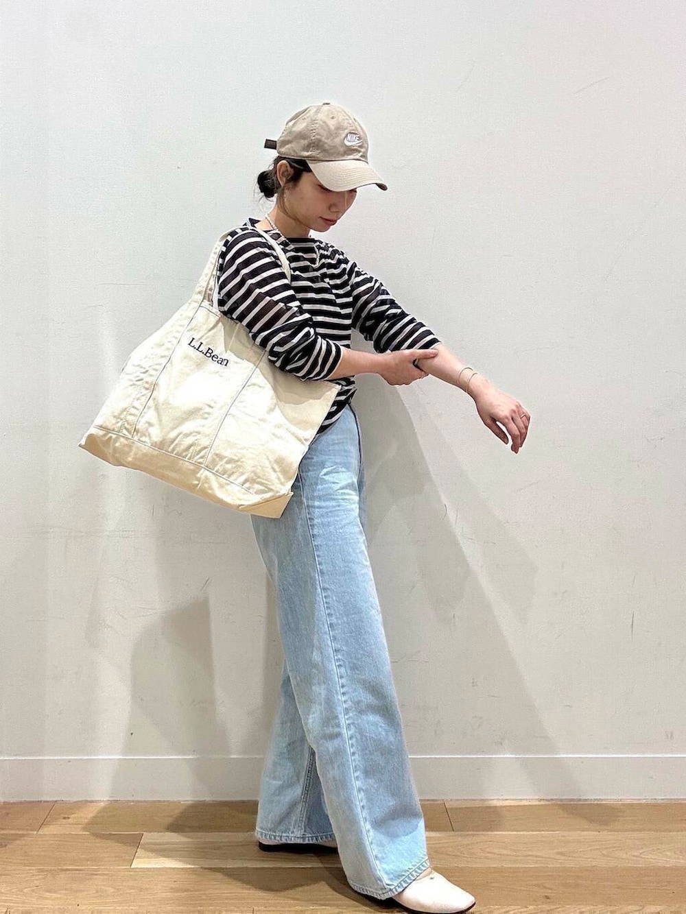 ブルー系のデニムパンツ、ホワイト系のバレエシューズ、ブルー系のTシャツ/カットソーを着用したレディースの春コーディネートの4枚目の写真