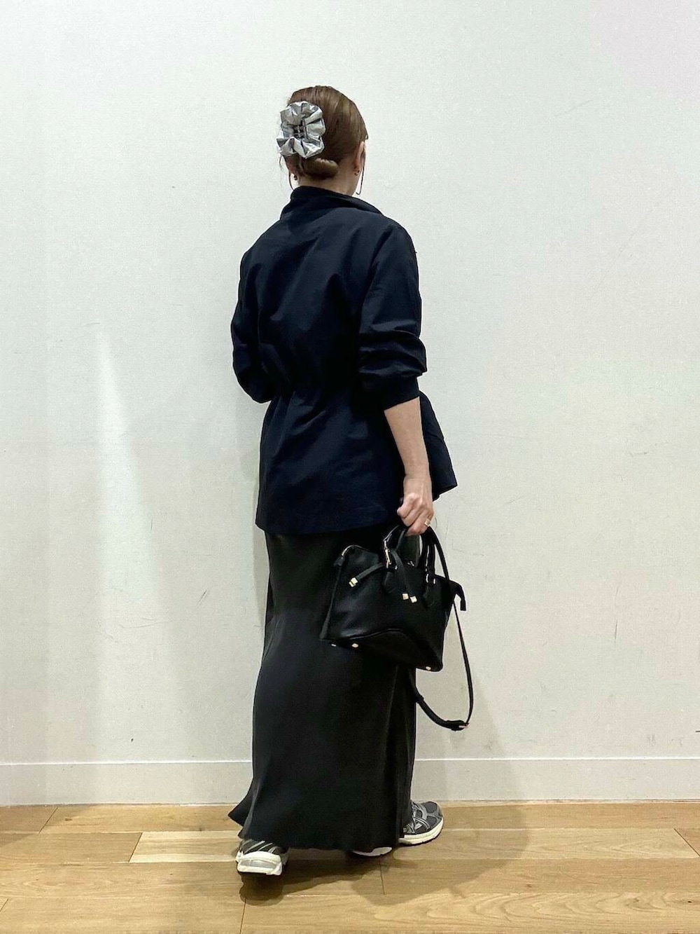 ブラウン系のタンクトップ、グレー系のスカート、ブラック系のボストンバッグを着用したレディースの秋コーディネートの3枚目の写真