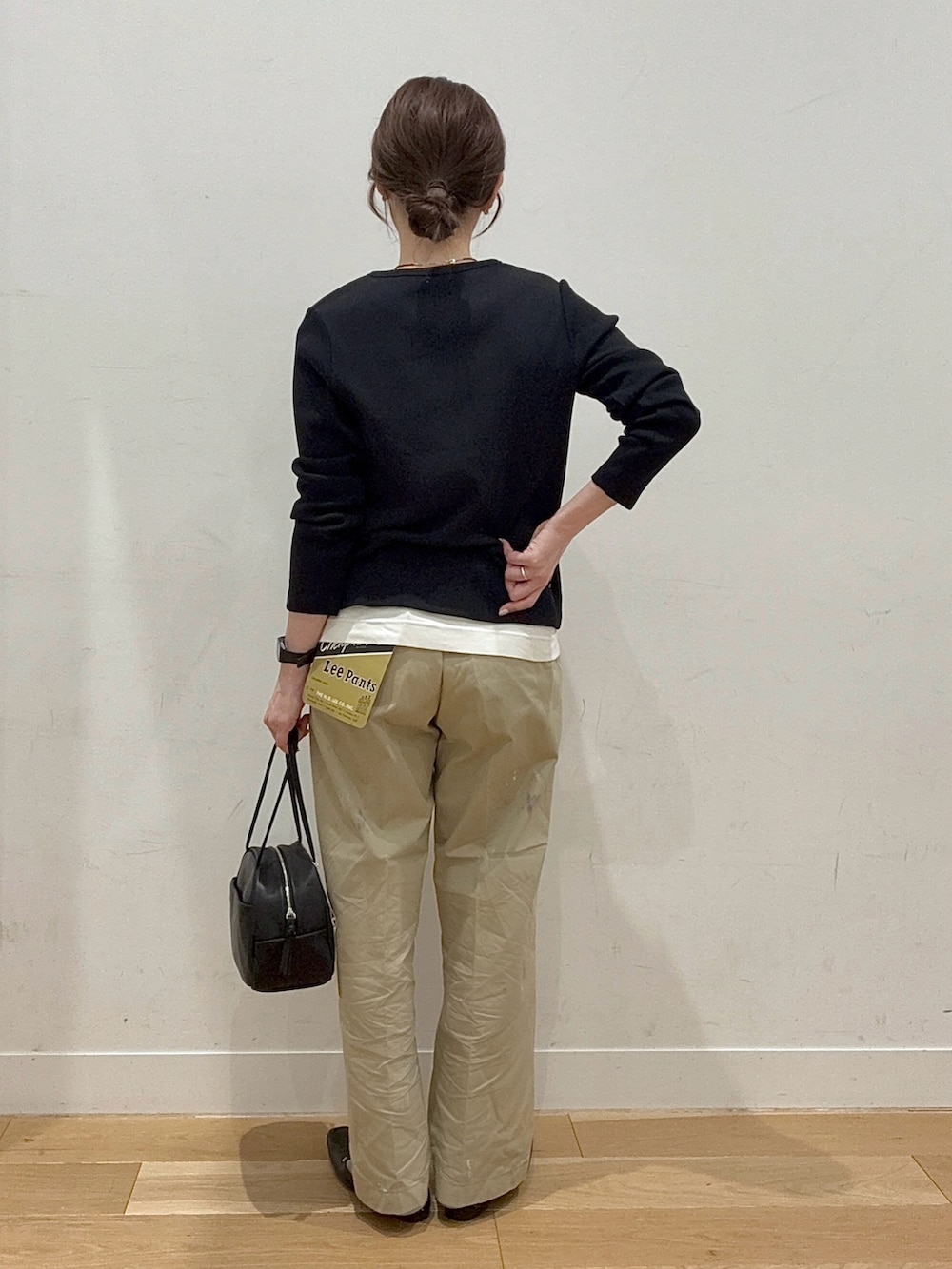 ブラック系のボストンバッグ、ブラック系のローファー、ホワイト系のタンクトップを着用したレディースの春コーディネートの3枚目の写真