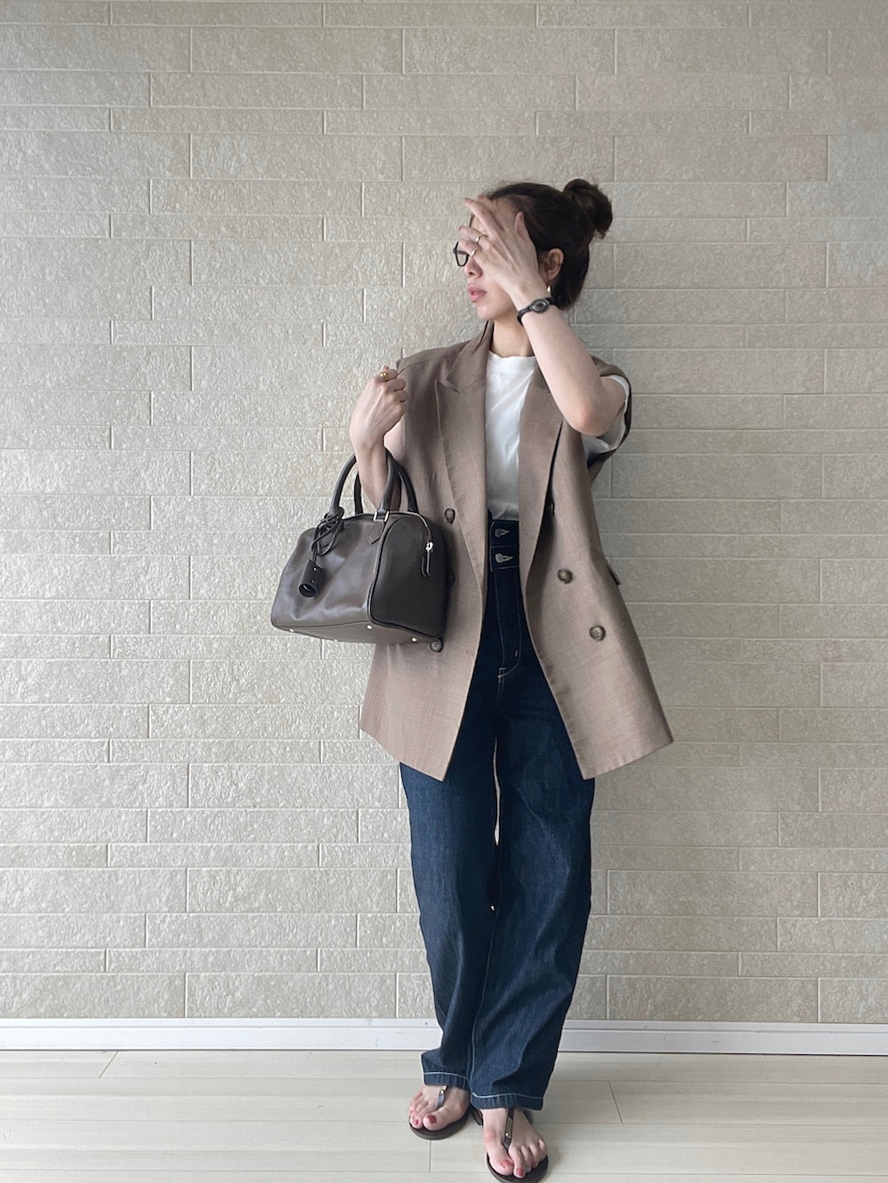 ブルー系のサロペット/オーバーオール、ブラウン系のベスト、ブラウン系のボストンバッグを着用したレディースの夏コーディネートの2枚目の写真