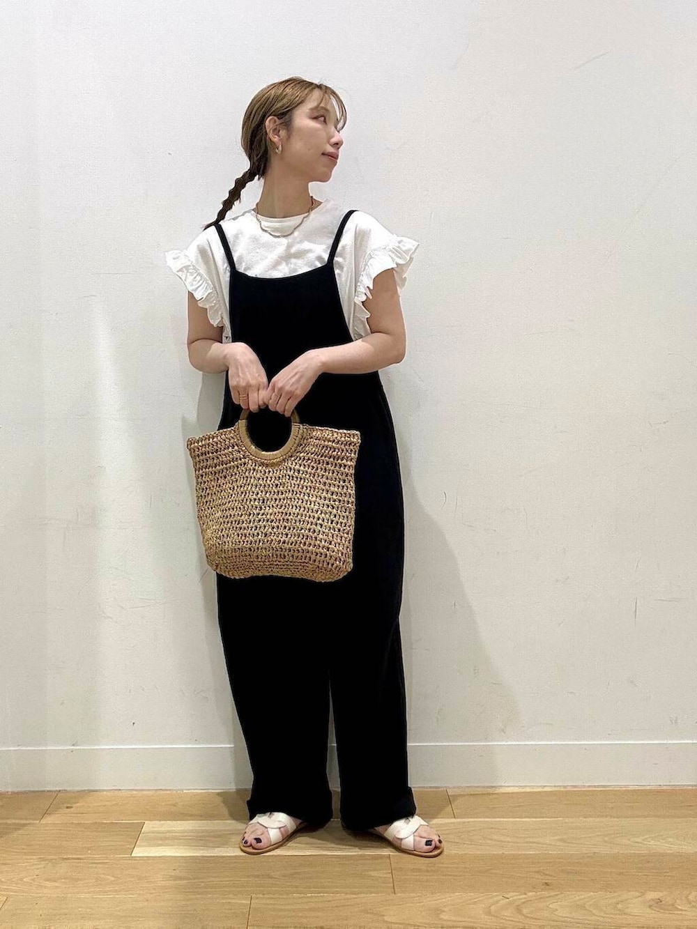 ホワイト系のサンダル、ベージュ系のトートバッグ、ブラック系のサロペット/オーバーオールを着用したレディースの春コーディネートの2枚目の写真