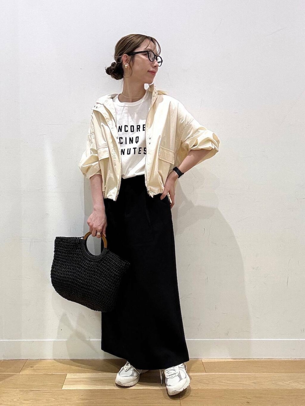 ベージュ系のスニーカー、ホワイト系のマウンテンパーカー、ブラック系のトートバッグを着用したレディースの春コーディネートの5枚目の写真