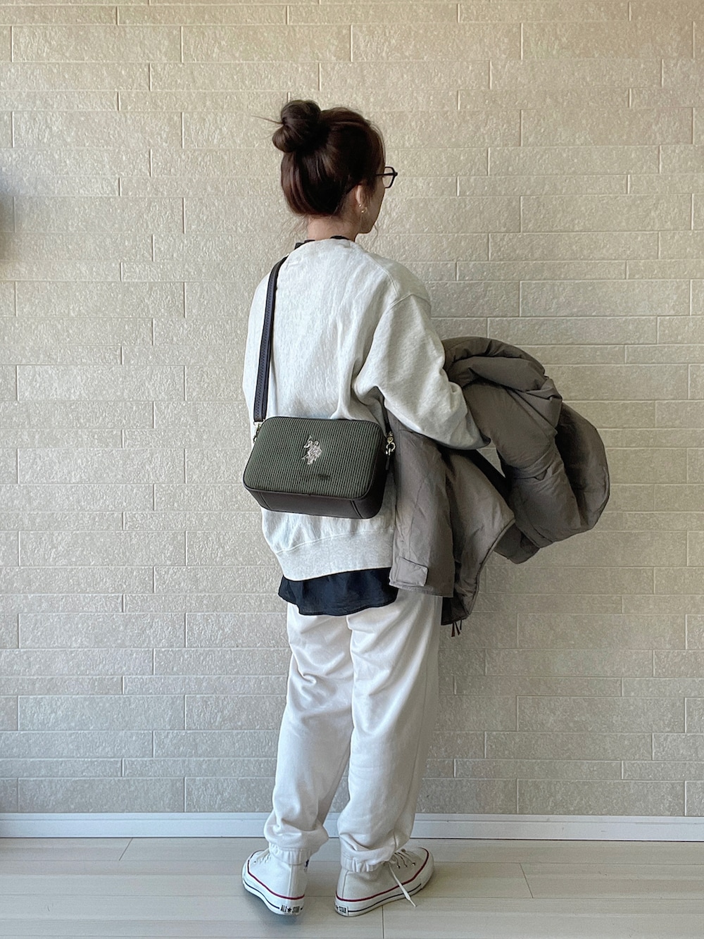 グリーン系のショルダーバッグ、ホワイト系のスニーカー、ベージュ系のスウェットを着用したレディースの冬コーディネートの5枚目の写真