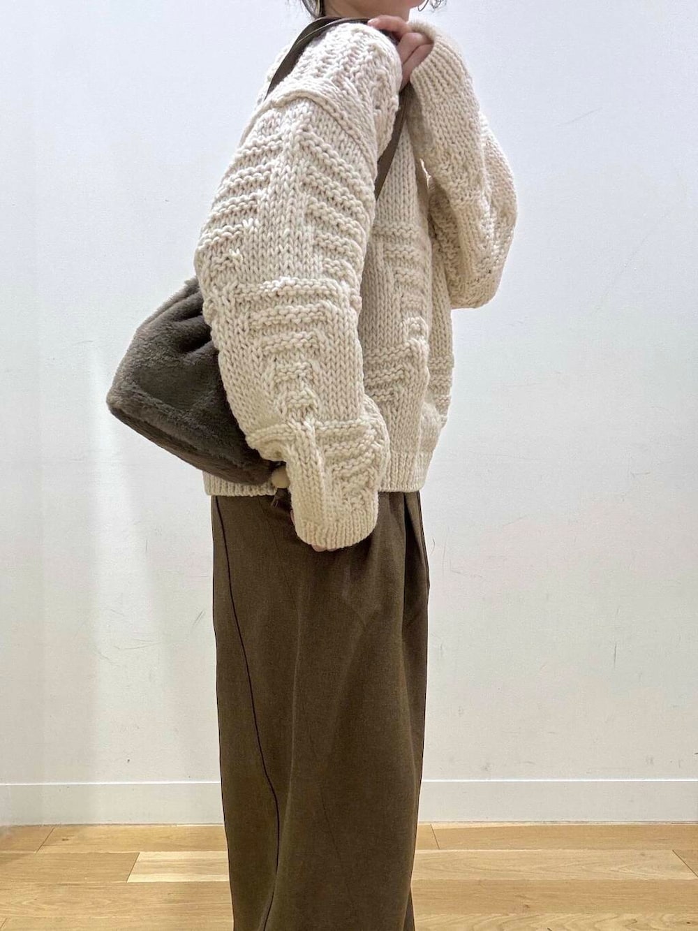 ブラウン系のタンクトップ、ホワイト系のニット/セーター、ブラウン系のブーツを着用したレディースの秋コーディネートの6枚目の写真