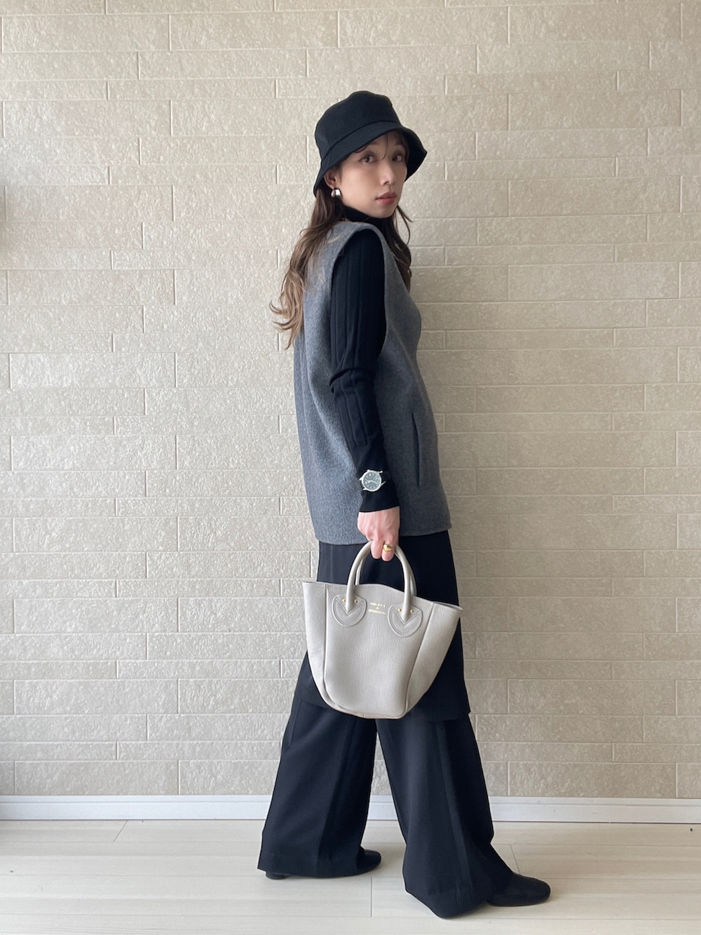 ベージュ系のトートバッグ、ブラック系のその他パンツ、グレー系のベストを着用したレディースの冬コーディネートの4枚目の写真