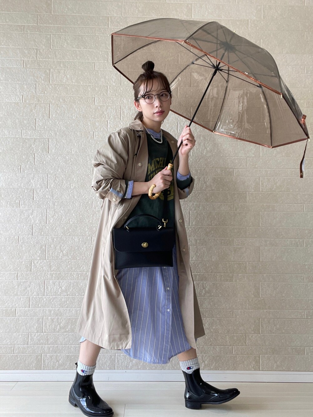 ブラック系のレインシューズ、ブラック系のショルダーバッグ、ブルー系のシャツワンピースを着用したレディースの春コーディネートの2枚目の写真