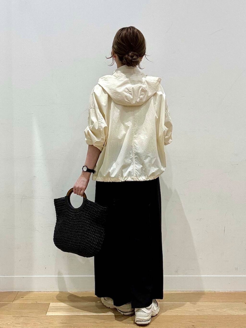 ベージュ系のスニーカー、ホワイト系のマウンテンパーカー、ブラック系のトートバッグを着用したレディースの春コーディネートの3枚目の写真