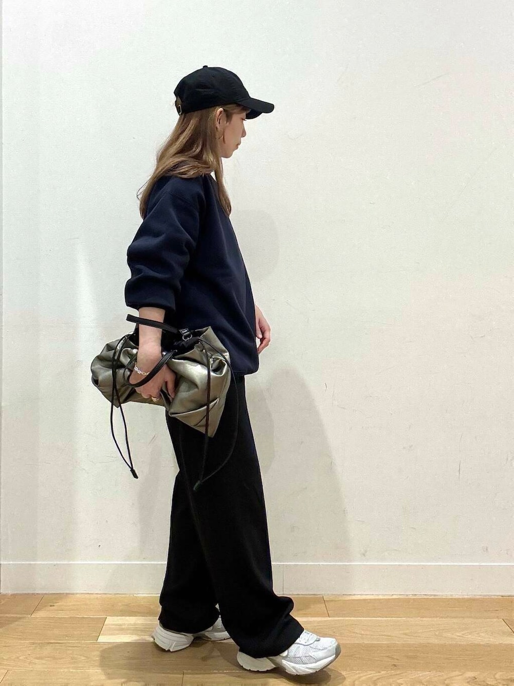 シルバー系のトートバッグ、シルバー系のスニーカー、ブルー系のスウェットを着用したレディースの冬コーディネートの3枚目の写真
