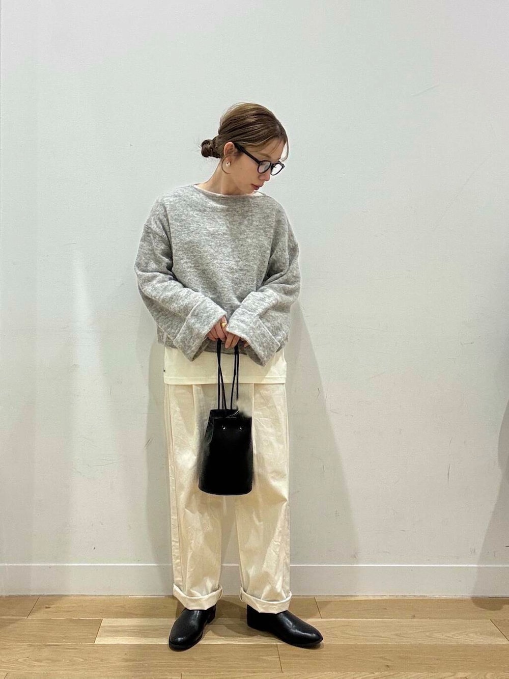 ホワイト系のトートバッグ、ベージュ系のデニムパンツ、ブラック系のブーツを着用したレディースの冬コーディネートの7枚目の写真