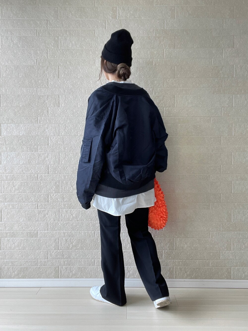 ブラック系のその他パンツ、オレンジ系のエコバッグ/サブバッグ、ホワイト系のスニーカーを着用したレディースの秋コーディネートの3枚目の写真