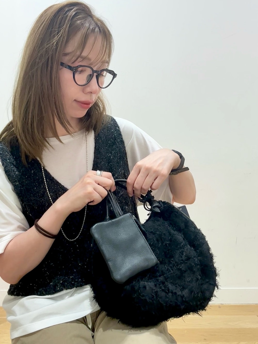 ベージュ系のその他パンツ、ホワイト系のTシャツ/カットソー、グレー系のニット/セーターを着用したレディースの夏コーディネートの5枚目の写真