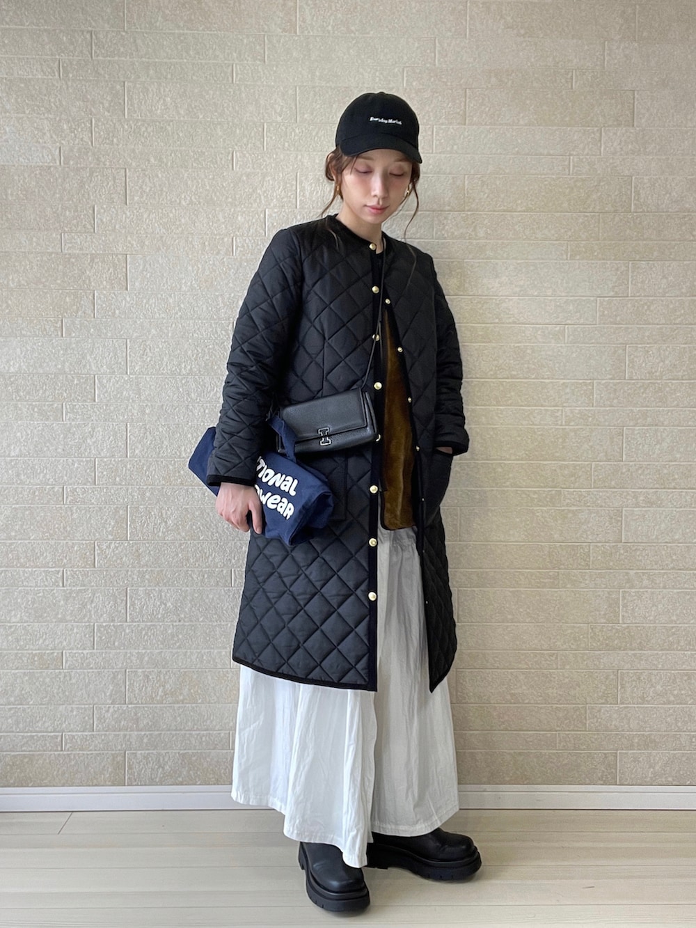 ブラック系のその他アウター、ブルー系のトートバッグ、ブラウン系のベストを着用したレディースの冬コーディネートの2枚目の写真