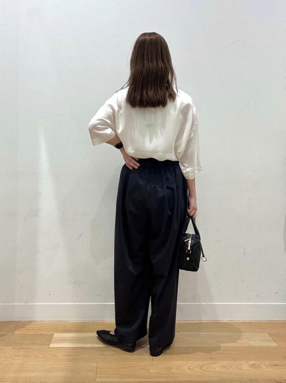 ブラック系のバレエシューズ、ブラック系のショルダーバッグ、ブルー系のその他パンツを着用したレディースの夏コーディネートの3枚目の写真