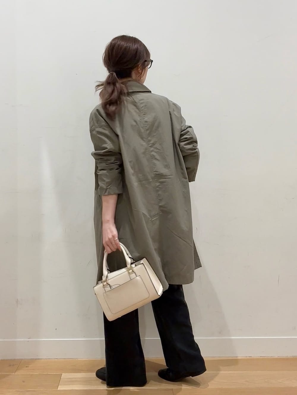 ホワイト系のハンドバッグ、ブラウン系のその他アウター、ブラック系のニット/セーターを着用したレディースの冬コーディネートの4枚目の写真