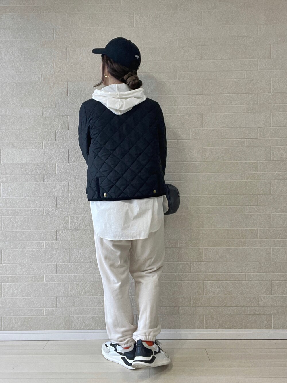 ブラック系のノーカラージャケット、ホワイト系のマウンテンパーカー、ホワイト系のスウェットパンツを着用したレディースの秋コーディネートの3枚目の写真