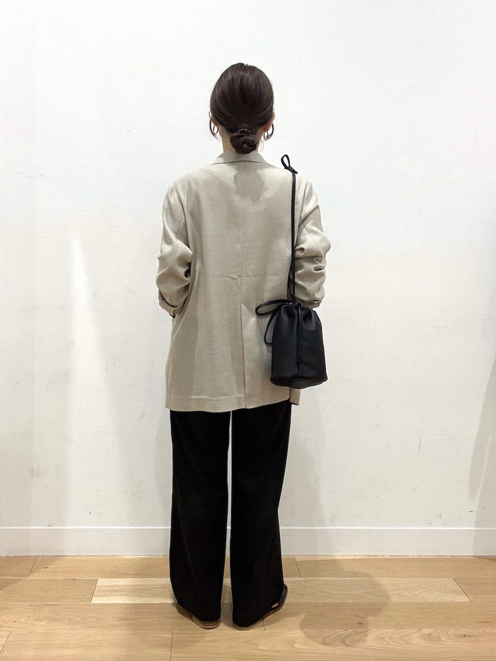 ベージュ系のその他アウター、ブラック系のショルダーバッグ、ホワイト系のTシャツ/カットソーを着用したレディースの春コーディネートの4枚目の写真