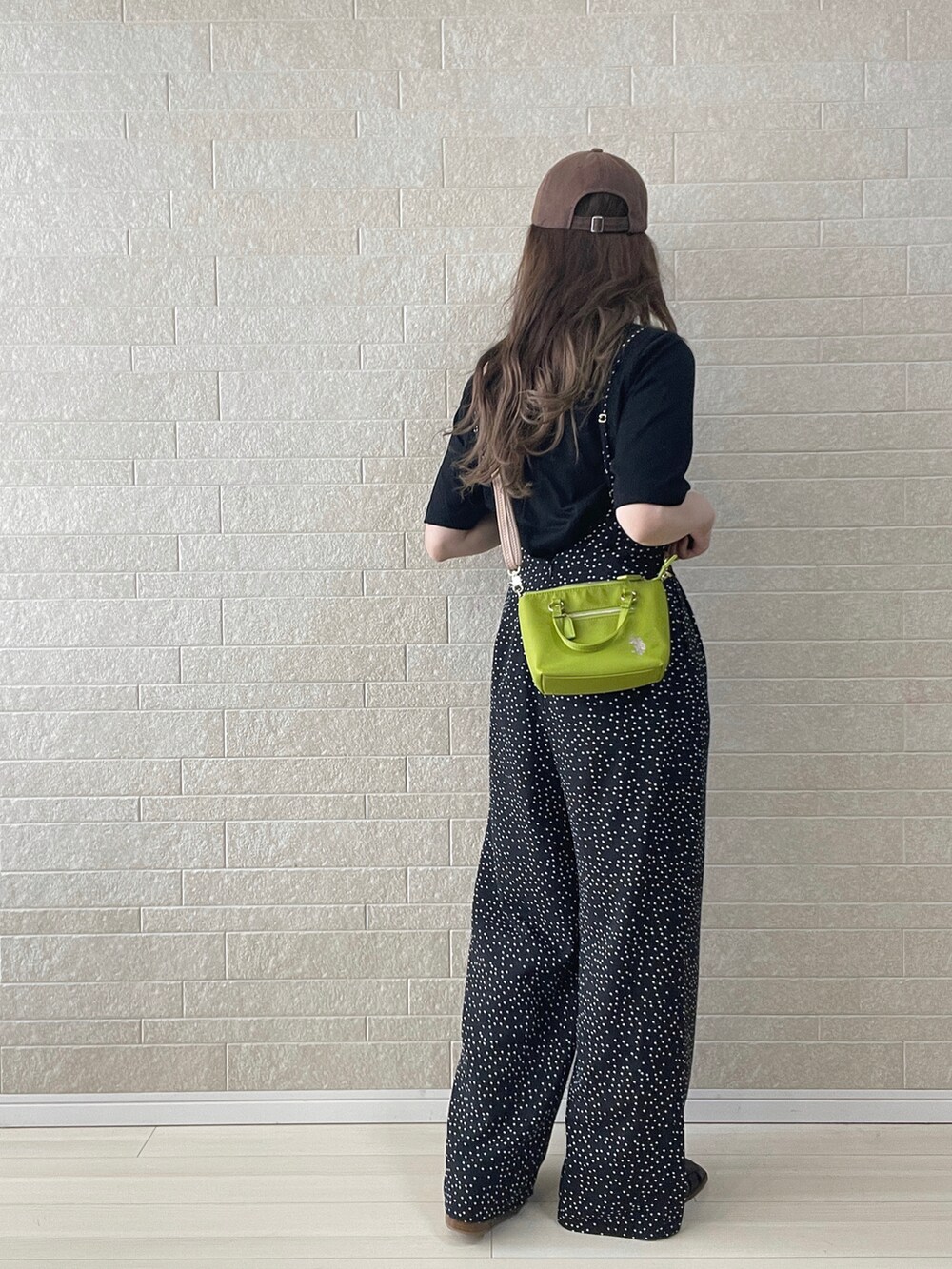 グリーン系のショルダーバッグ、ブラック系のサロペット/オーバーオール、ブラック系のサンダルを着用したレディースの夏コーディネートの3枚目の写真