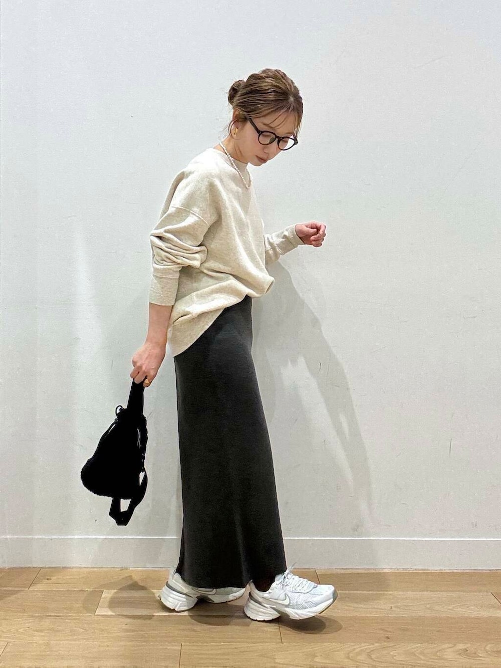 ホワイト系のスニーカー、グレー系のスカート、ホワイト系のダウンジャケット/コートを着用したレディースの冬コーディネートの6枚目の写真