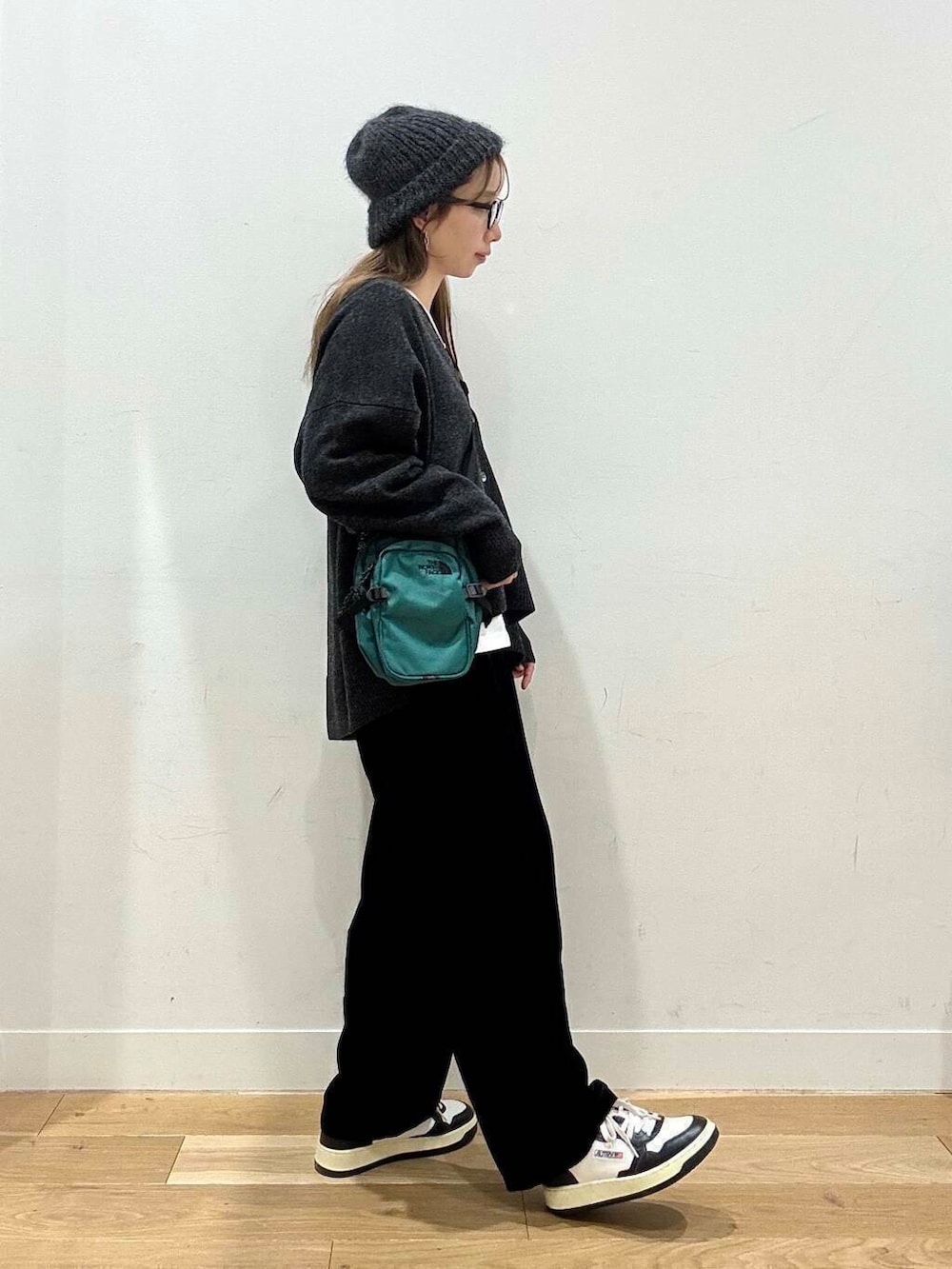 ブラック系のその他パンツ、ホワイト系のTシャツ/カットソー、グレー系のニット/セーターを着用したレディースの冬コーディネートの3枚目の写真