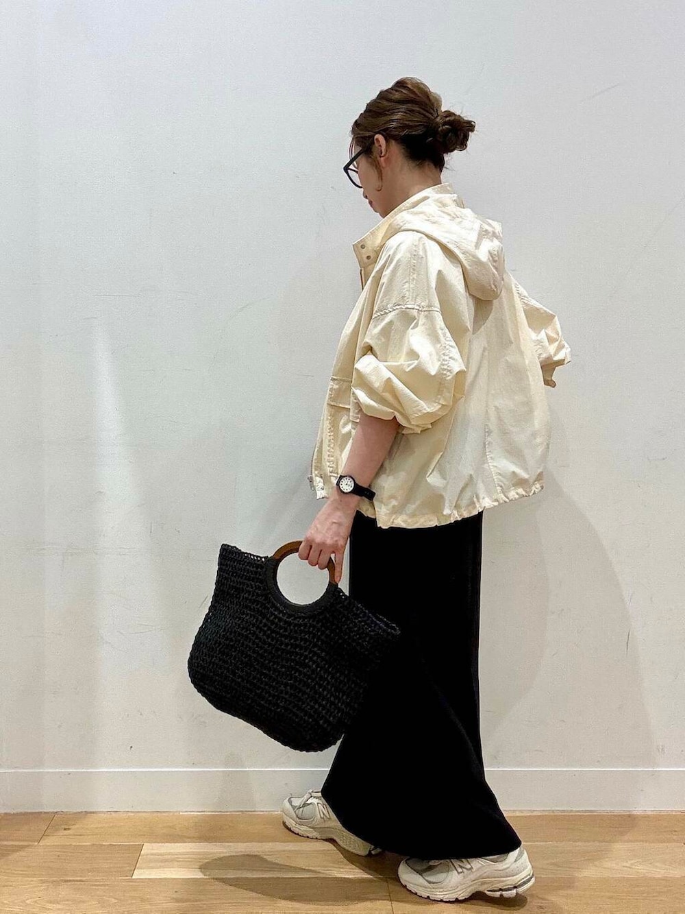 ベージュ系のスニーカー、ホワイト系のマウンテンパーカー、ブラック系のトートバッグを着用したレディースの春コーディネートの4枚目の写真