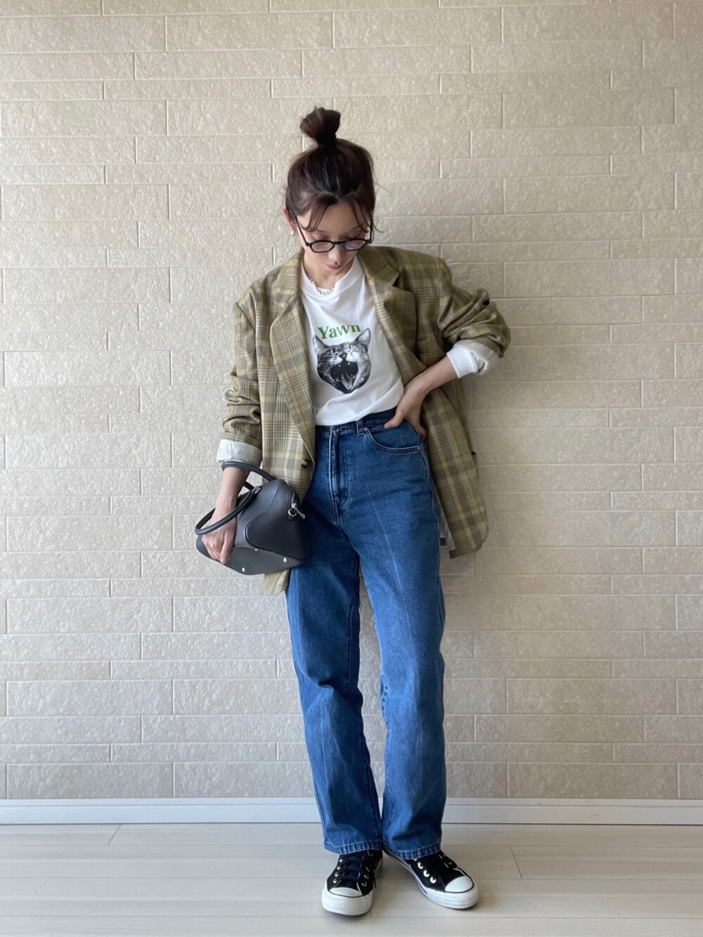 ホワイト系のTシャツ/カットソー、ブルー系のデニムパンツ、グレー系のボストンバッグを着用したレディースの秋コーディネートの2枚目の写真