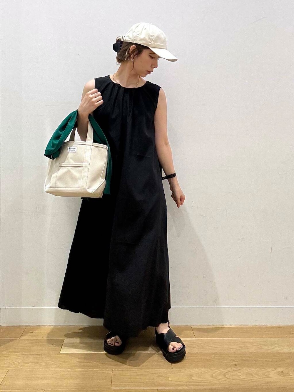 ブラック系のサンダル、グリーン系のカーディガン/ボレロ、ブラック系のワンピースを着用したレディースの夏コーディネートの3枚目の写真