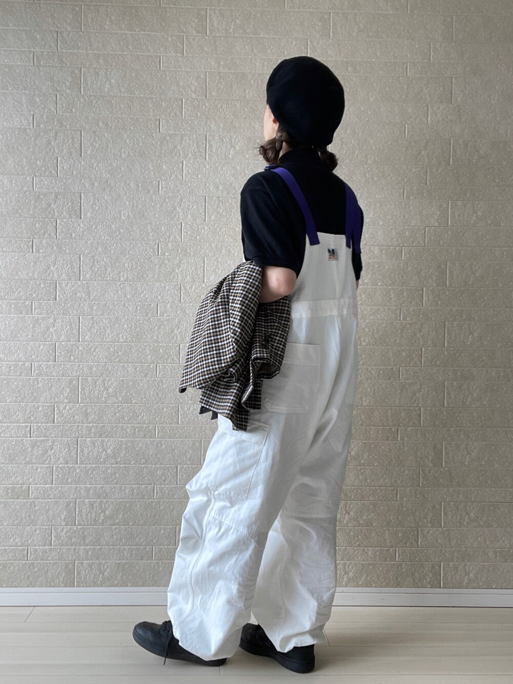 ホワイト系のサロペット/オーバーオール、ブラック系のポロシャツ、ブラック系のショルダーバッグを着用したレディースの秋コーディネートの4枚目の写真