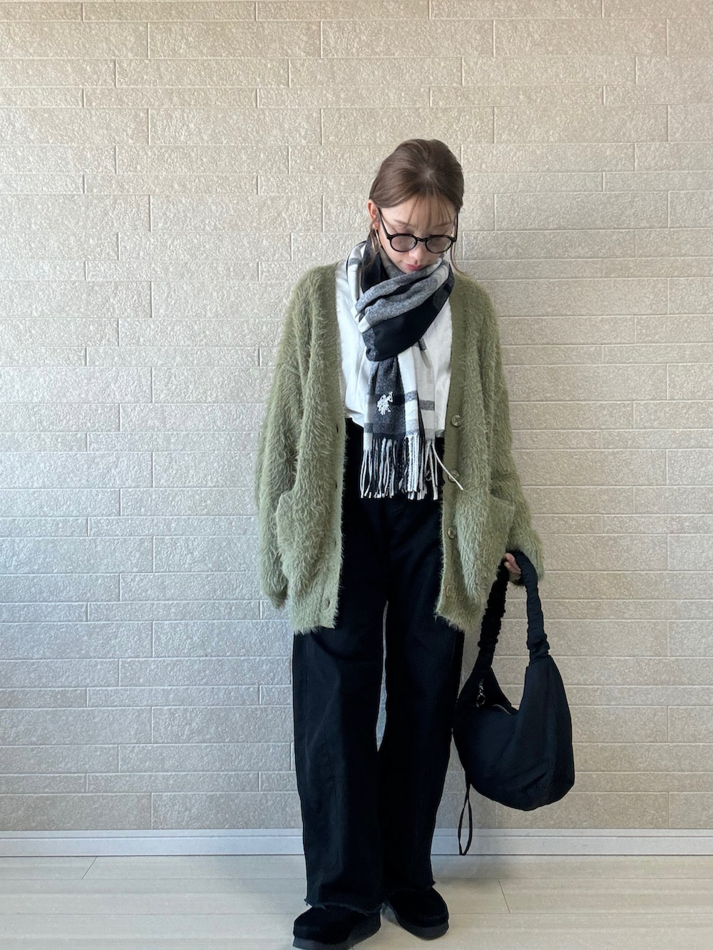 グリーン系のカーディガン/ボレロ、ブラック系のショルダーバッグ、ブラック系のモカシン/デッキシューズを着用したレディースの冬コーディネートの2枚目の写真