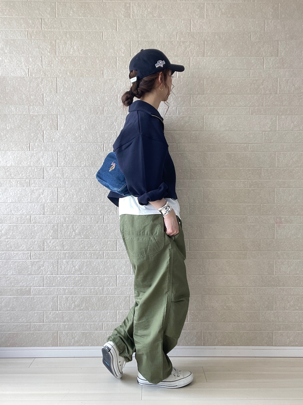 グリーン系のカーゴパンツ、ブルー系のショルダーバッグ、ホワイト系のスニーカーを着用したレディースの春コーディネートの3枚目の写真