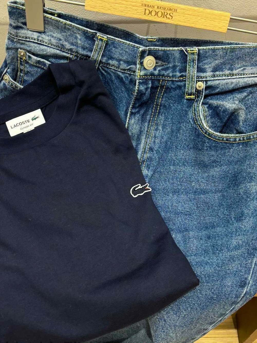 ブルー系のデニムパンツ、ホワイト系のスニーカー、グレー系のトートバッグを着用したレディースの秋コーディネートの7枚目の写真