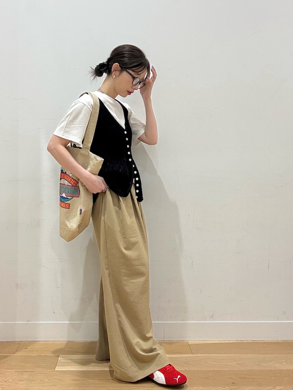 レッド系のスニーカー、ベージュ系のその他パンツ、ブラウン系のトートバッグを着用したレディースの夏コーディネートの3枚目の写真