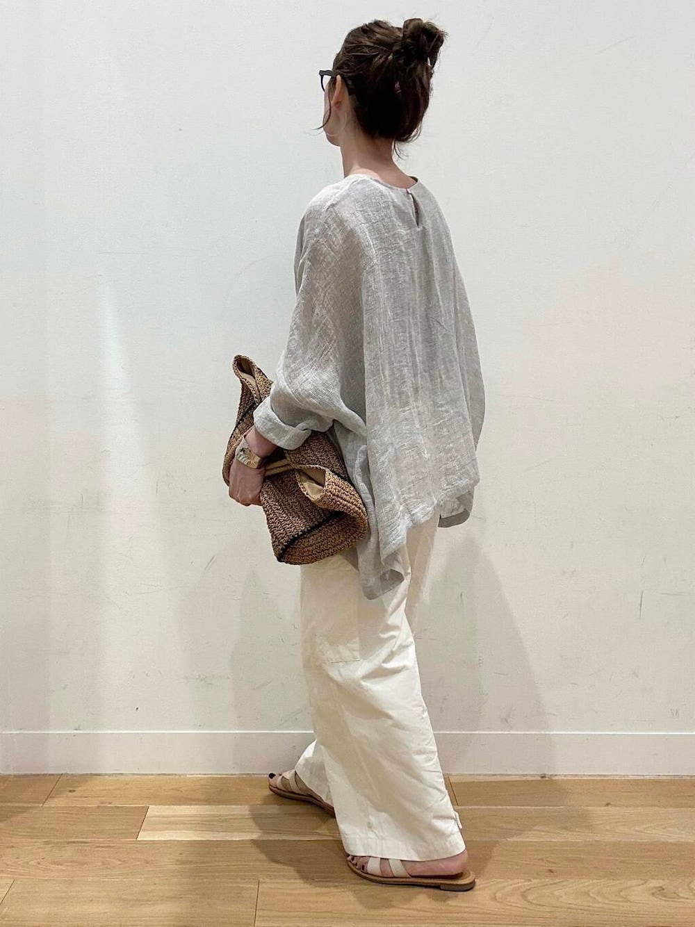 ベージュ系のトートバッグ、ホワイト系のサンダル、ベージュ系のタンクトップを着用したレディースの春コーディネートの5枚目の写真