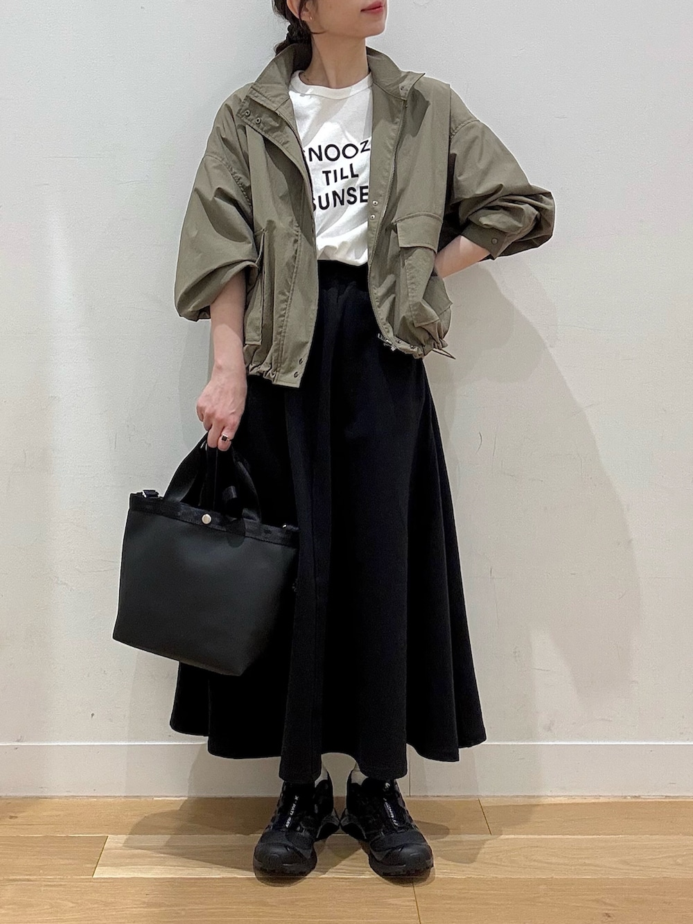 グリーン系のブルゾン、ブラック系のハンドバッグ、その他のTシャツ/カットソーを着用したレディースの春コーディネートの2枚目の写真