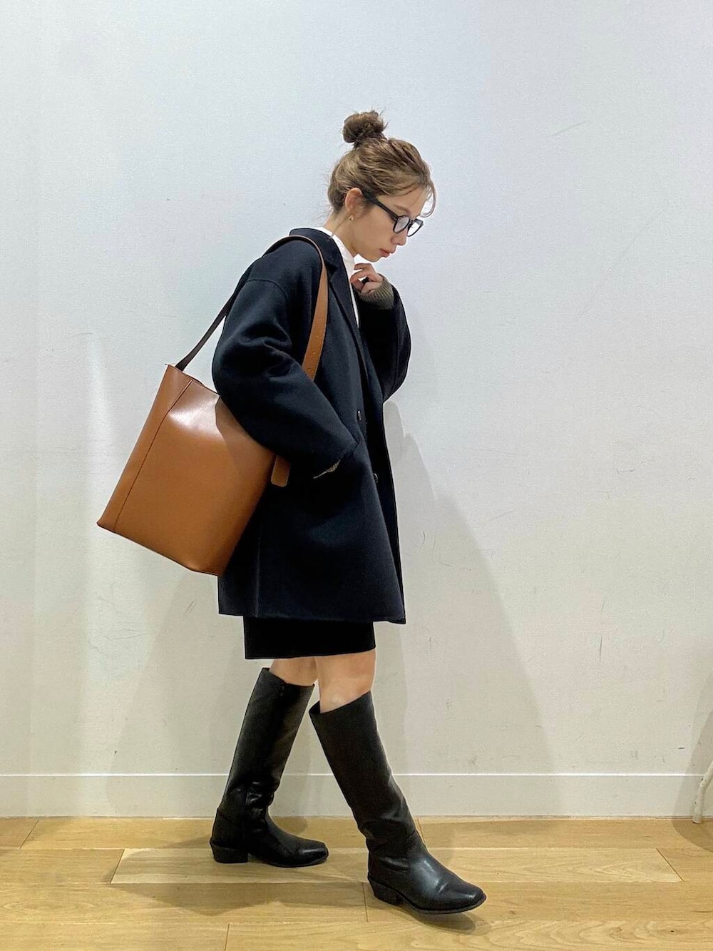 ブルー系のその他アウター、ホワイト系のシャツ/ブラウス、ブラウン系のトートバッグを着用したレディースの冬コーディネートの3枚目の写真