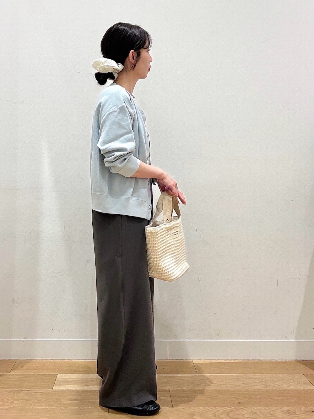 ホワイト系のトートバッグ、ブルー系のカーディガン/ボレロ、ホワイト系のタンクトップを着用したレディースの春コーディネートの5枚目の写真