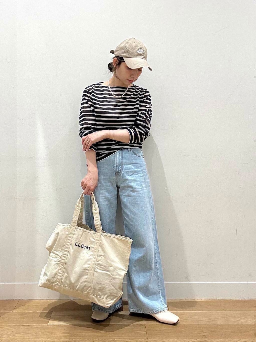 ブルー系のデニムパンツ、ホワイト系のバレエシューズ、ブルー系のTシャツ/カットソーを着用したレディースの春コーディネートの2枚目の写真