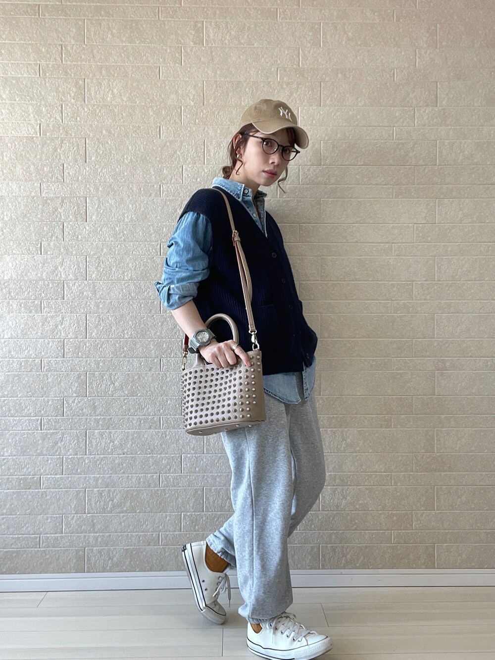 ベージュ系のトートバッグ、ブルー系のベスト、ブルー系のシャツ/ブラウスを着用したレディースの春コーディネートの4枚目の写真