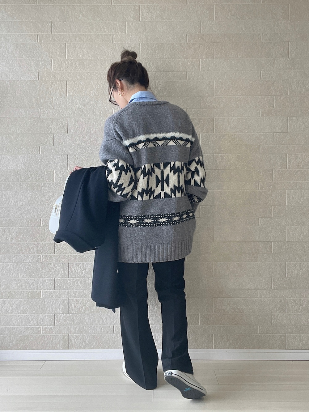 ホワイト系のハンドバッグ、グレー系のカーディガン/ボレロ、ブラック系のその他パンツを着用したレディースの冬コーディネートの4枚目の写真