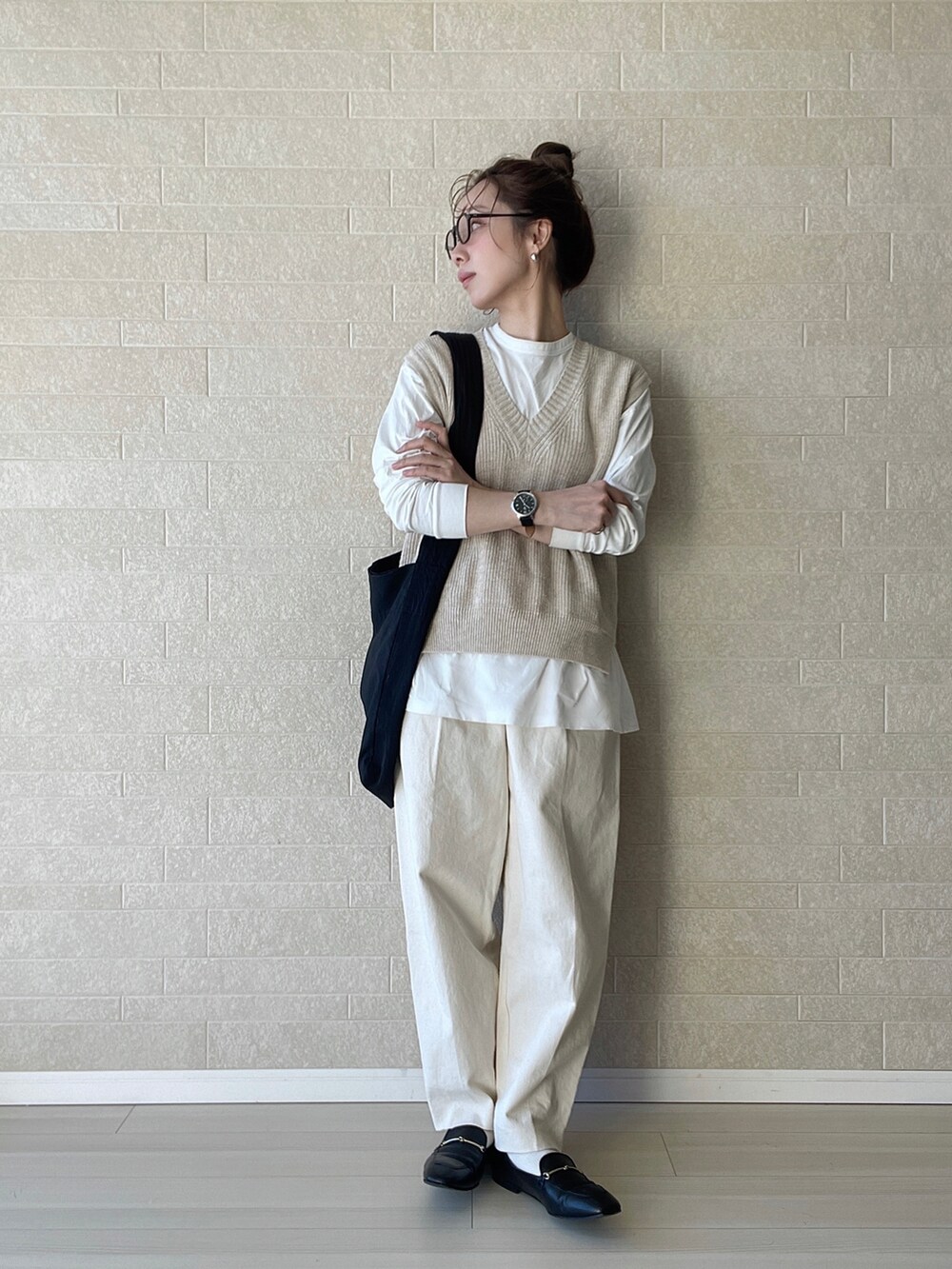 ホワイト系のその他パンツ、ブラック系のショルダーバッグ、ベージュ系のベストを着用したレディースの冬コーディネートの2枚目の写真