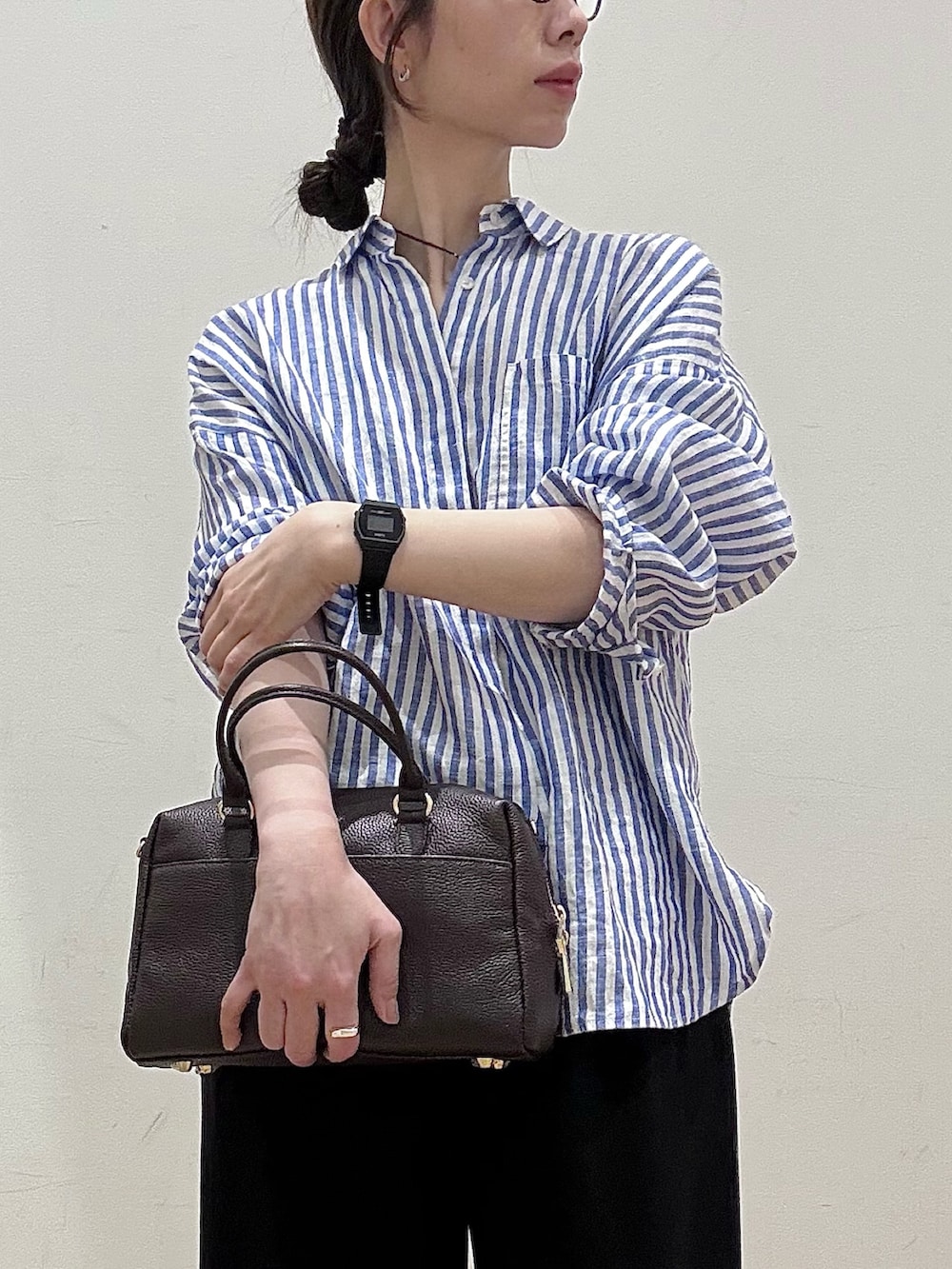 ホワイト系のブルゾン、ブラウン系のボストンバッグ、ブラック系のその他パンツを着用したレディースの春コーディネートの4枚目の写真